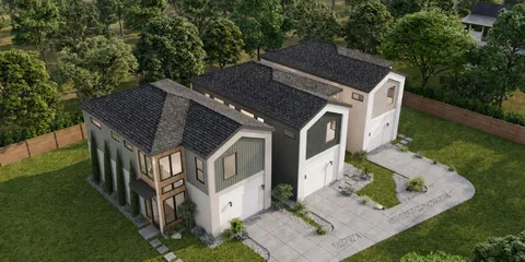 aerial view of house with yard and trees in the background