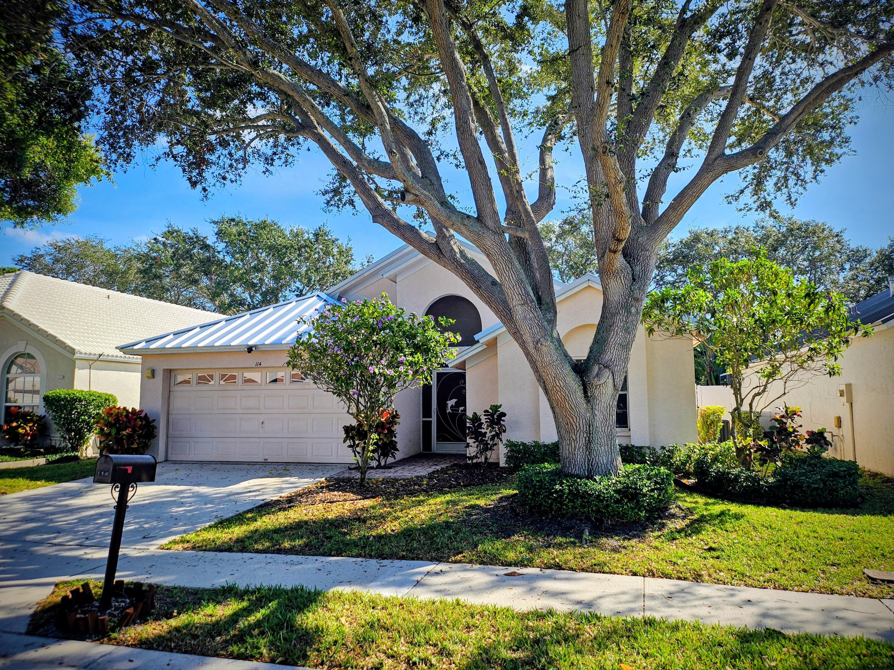 114 Spoonbill Court Jupiter, FL 33458 - Photo 2 of 12 a front view of a house with garden