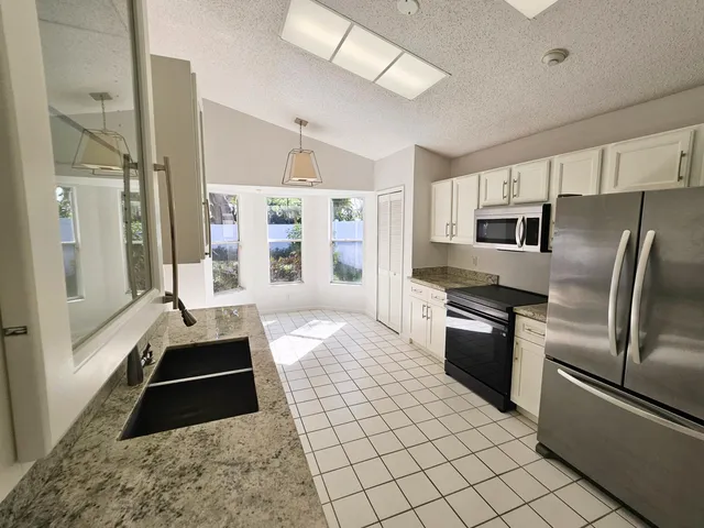 a large kitchen with a stove a refrigerator and a sink