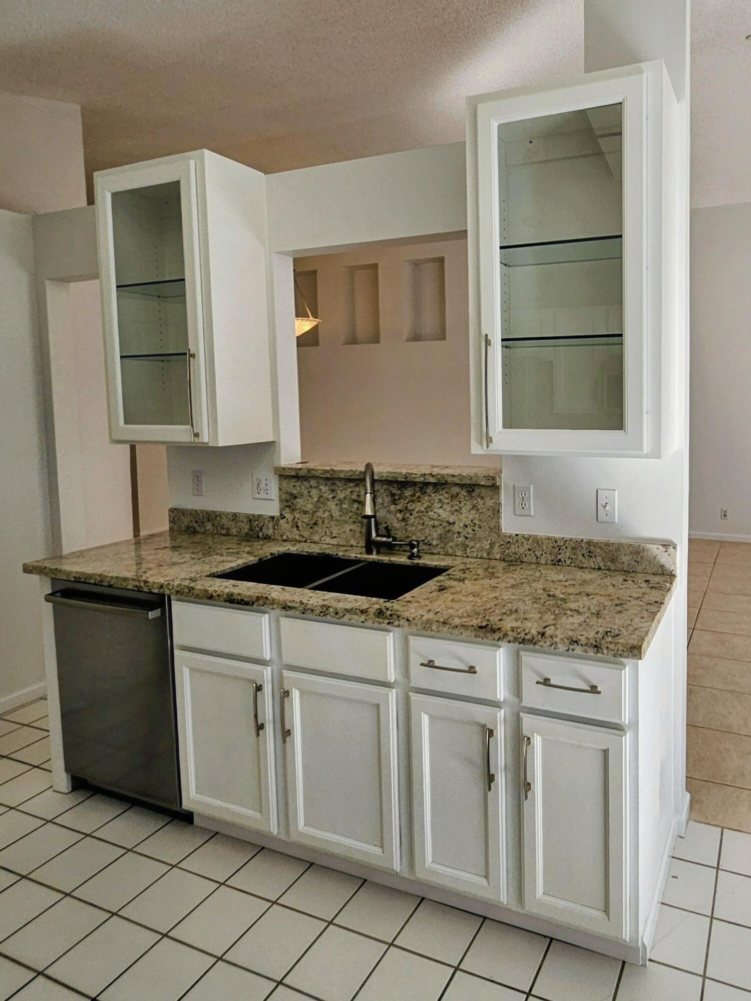 114 Spoonbill Court Jupiter, FL 33458 - Photo 6 of 12 a kitchen with granite countertop white cabinets and sink