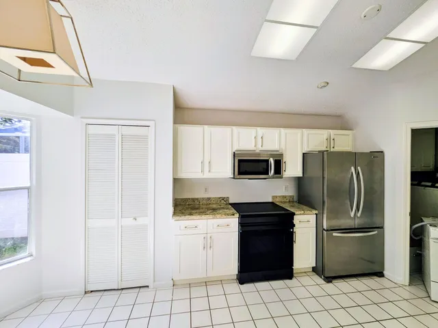a kitchen with a refrigerator sink and cabinets