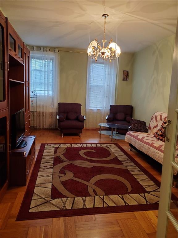 1053 East 13th Street, Unit B1 Brooklyn, NY 11230 - Photo 3 of 17 a living room with furniture and a chandelier