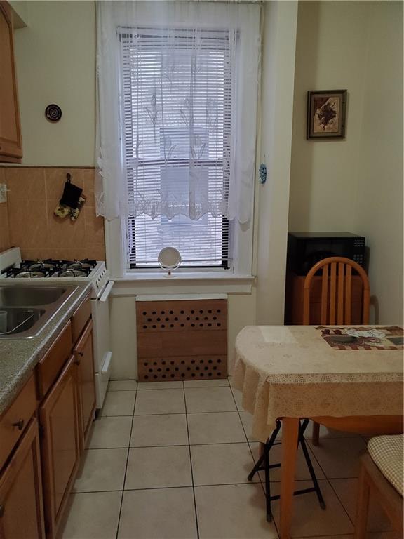1053 East 13th Street, Unit B1 Brooklyn, NY 11230 - Photo 7 of 17 a kitchen with a sink a stove and cabinets
