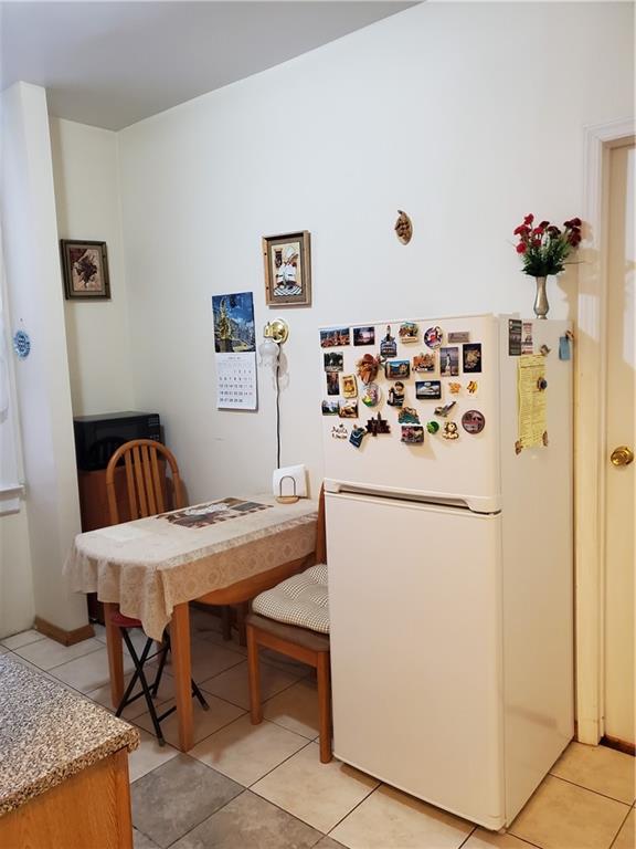 1053 East 13th Street, Unit B1 Brooklyn, NY 11230 - Photo 8 of 17 a white kitchen with a table and refrigerator