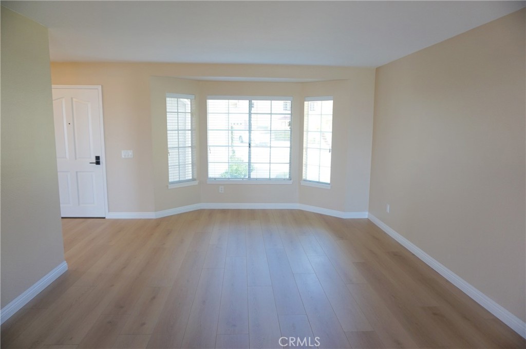19584 Shadow Glen Circle Porter Ranch, CA 91326 - Photo 6 of 72 an empty room with wooden floor and windows