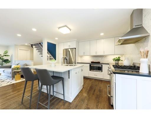 14 Thomas Park Boston, MA 02127 - Photo 3 of 20 a kitchen with stainless steel appliances granite countertop a sink dishwasher a stove a refrigerator a microwave oven with white cabinets and wooden floor