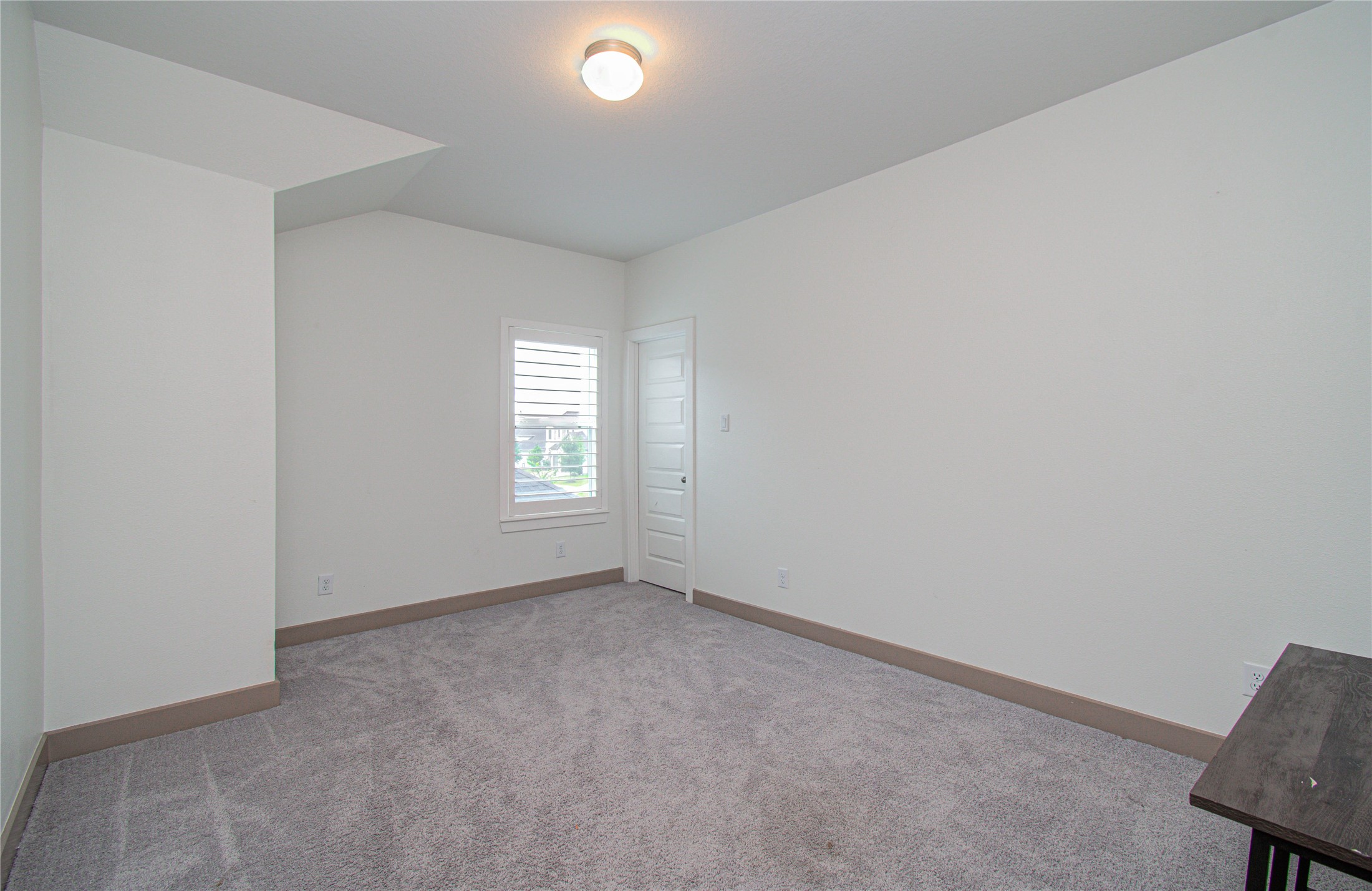 4211 Limestone Terrace Manvel, TX 77578 - Photo 29 of 33 This room features soft carpet flooring, neutral walls, and a ceiling light. It has a window with blinds and a modern door, creating a cozy and inviting space.