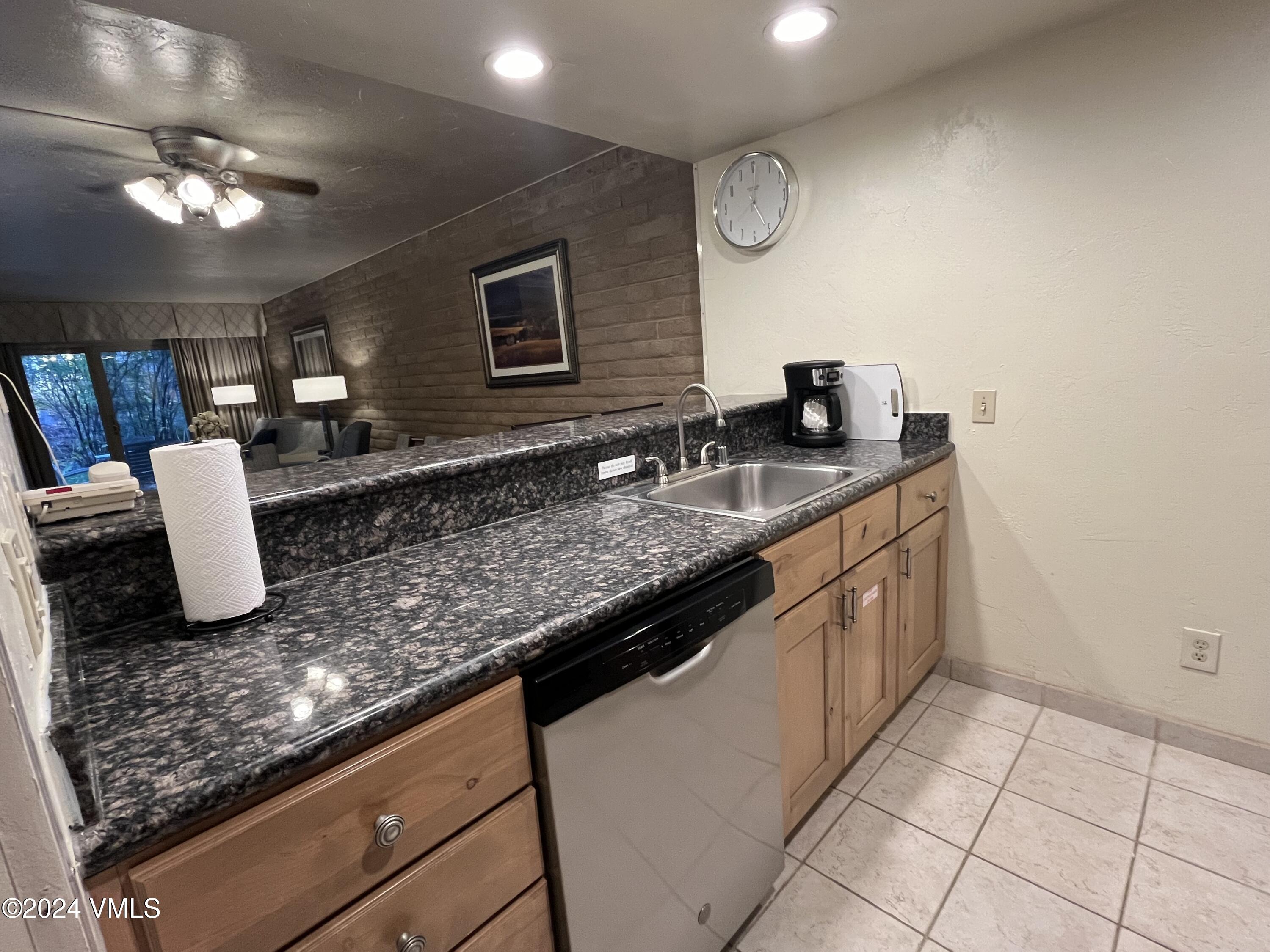1020 Vail View Drive, Unit 310438 Vail, CO 81657 - Photo 2 of 25 a kitchen with granite countertop a sink a counter top space and cabinets