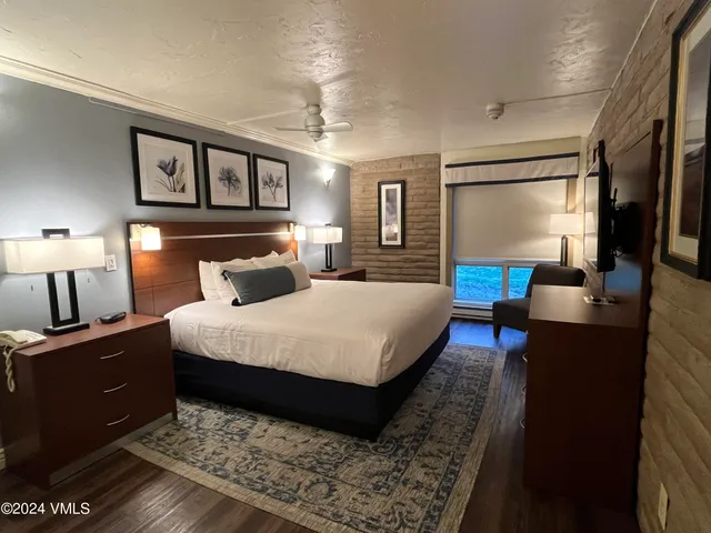 a bedroom with a bed a mirror and furniture