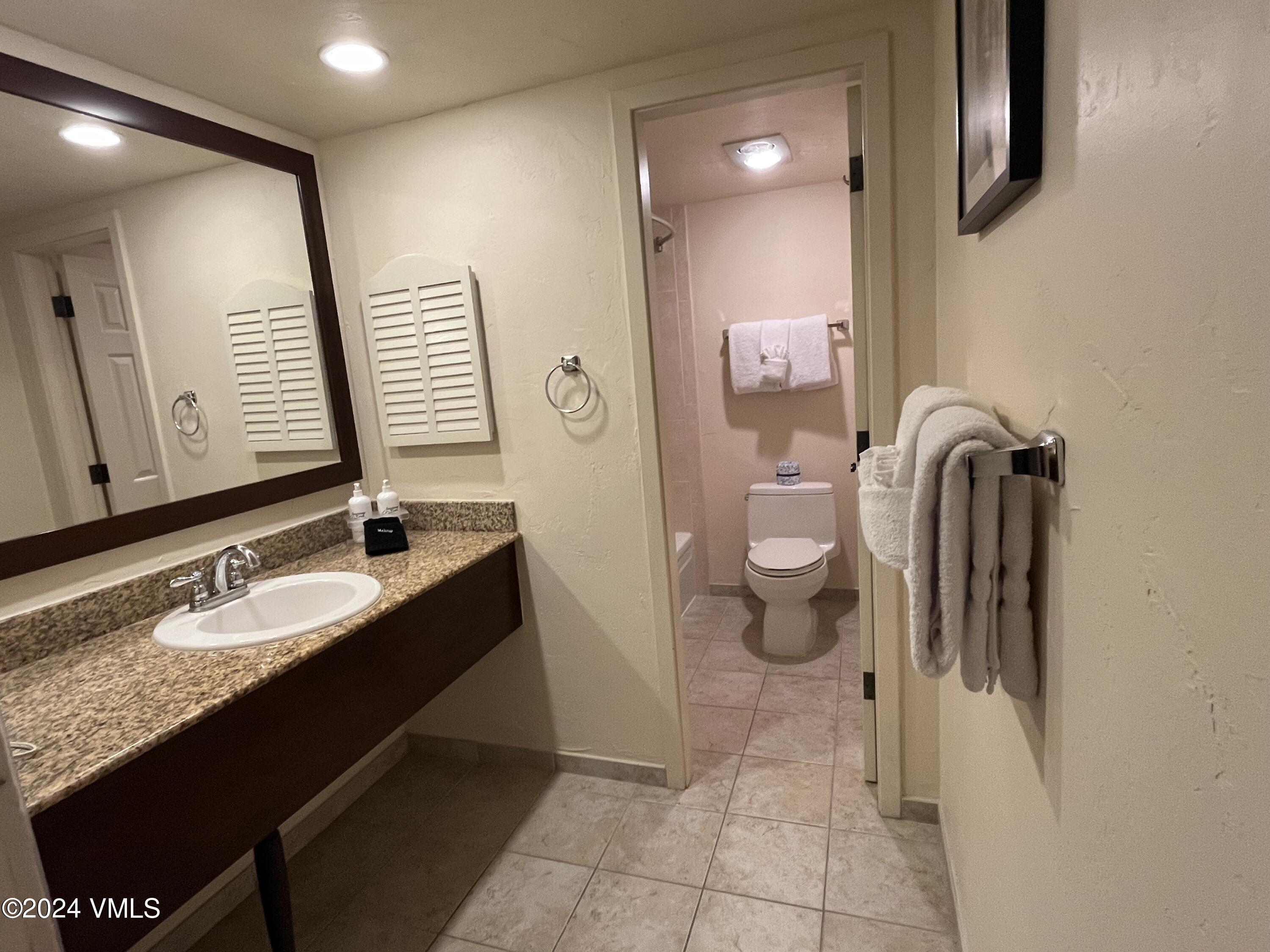 1020 Vail View Drive, Unit 310438 Vail, CO 81657 - Photo 10 of 25 a bathroom with a granite countertop sink and a mirror