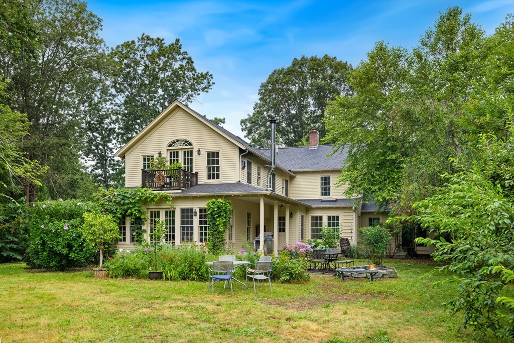244 Lincoln Road Lincoln, MA 01773 - Photo 1 of 41 a front view of a house with a yard table and chairs