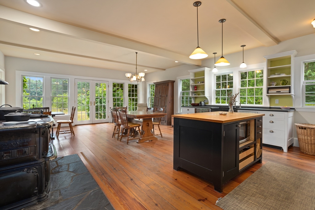 244 Lincoln Road Lincoln, MA 01773 - Photo 7 of 41 a kitchen with a stove a sink a counter space dining table and chairs