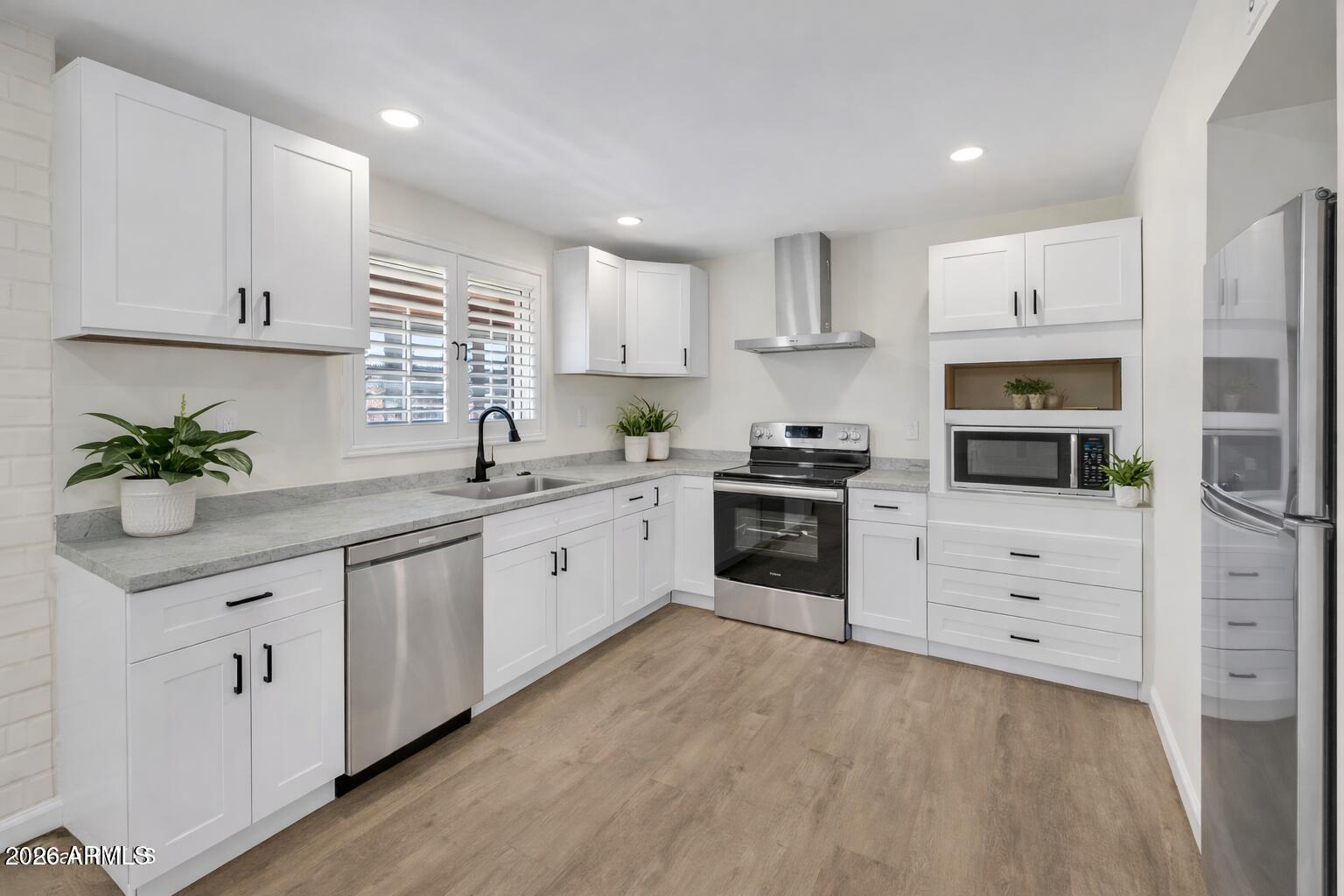 6735 North 16th Street, Unit 4 Phoenix, AZ 85016 - Photo 3 of 27 a kitchen with white cabinets stainless steel appliances and window