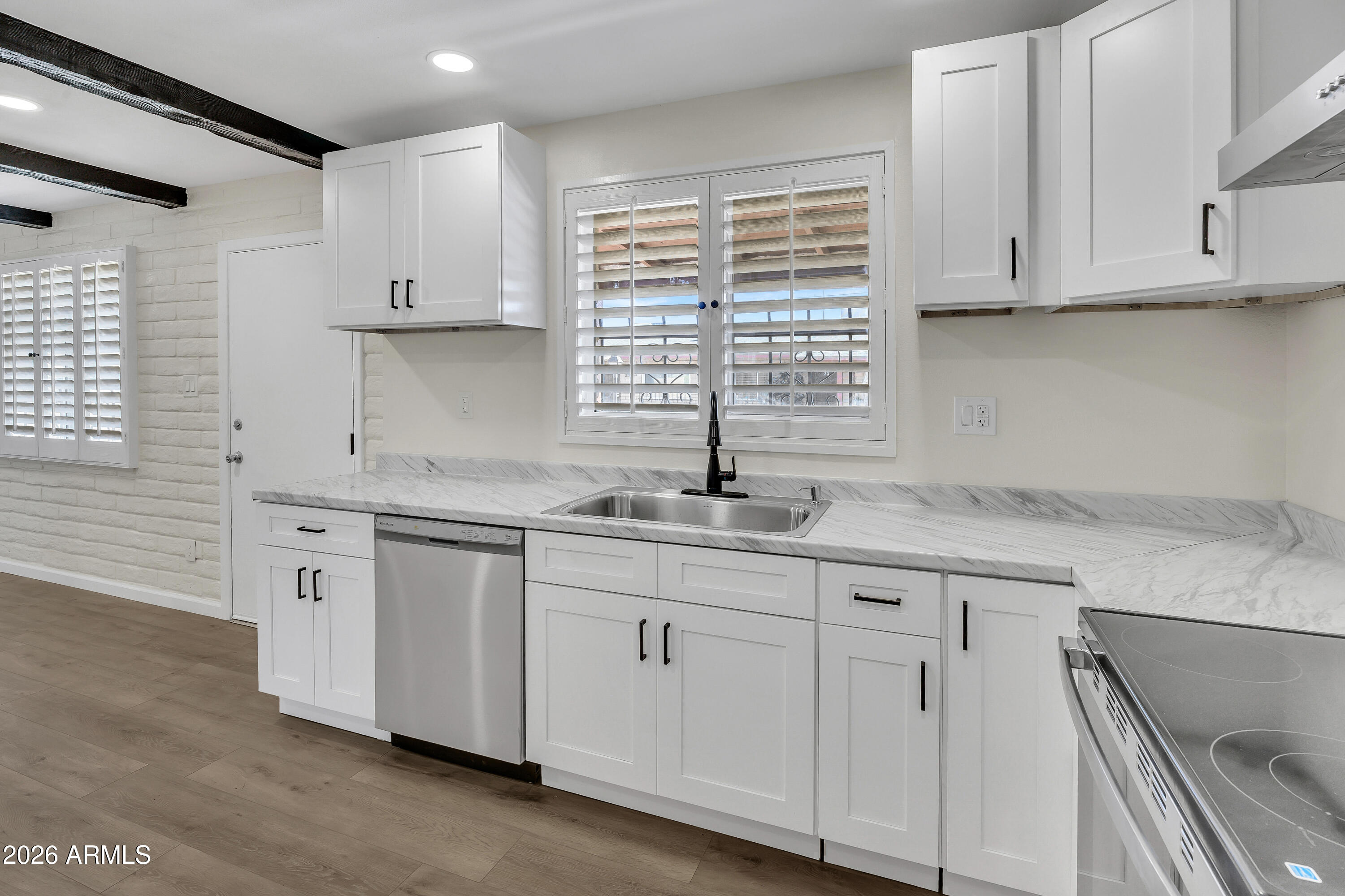 6735 North 16th Street, Unit 4 Phoenix, AZ 85016 - Photo 6 of 27 a kitchen with granite countertop white cabinets and a sink