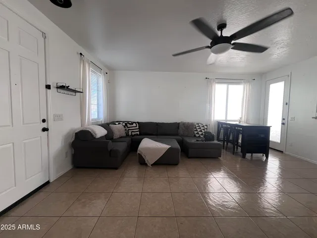 a living room with furniture and a ceiling fan