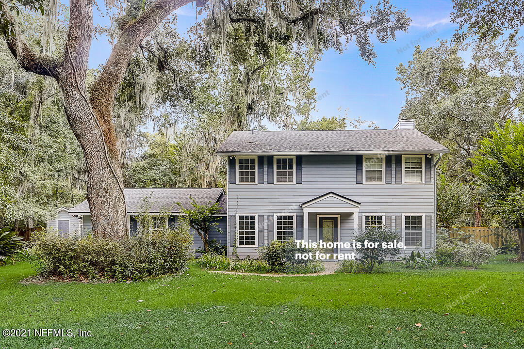 a front view of a house with a garden and yard