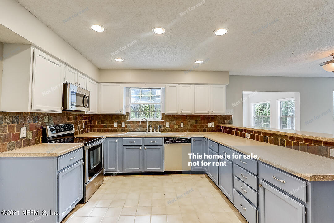 328 North Ridge Drive Orange Park, FL 32003 - Photo 14 of 33 a large kitchen with stainless steel appliances granite countertop a stove and a sink