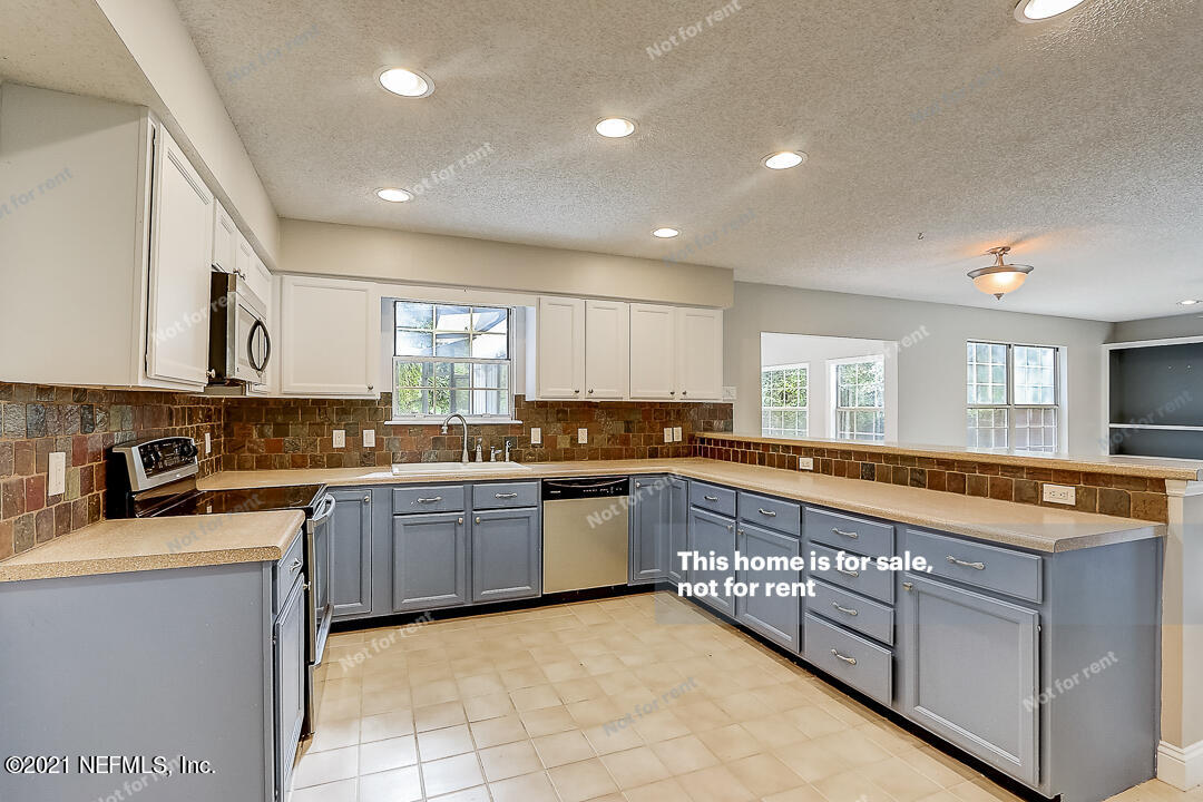 328 North Ridge Drive Orange Park, FL 32003 - Photo 15 of 33 a large kitchen with stainless steel appliances granite countertop a sink and cabinets