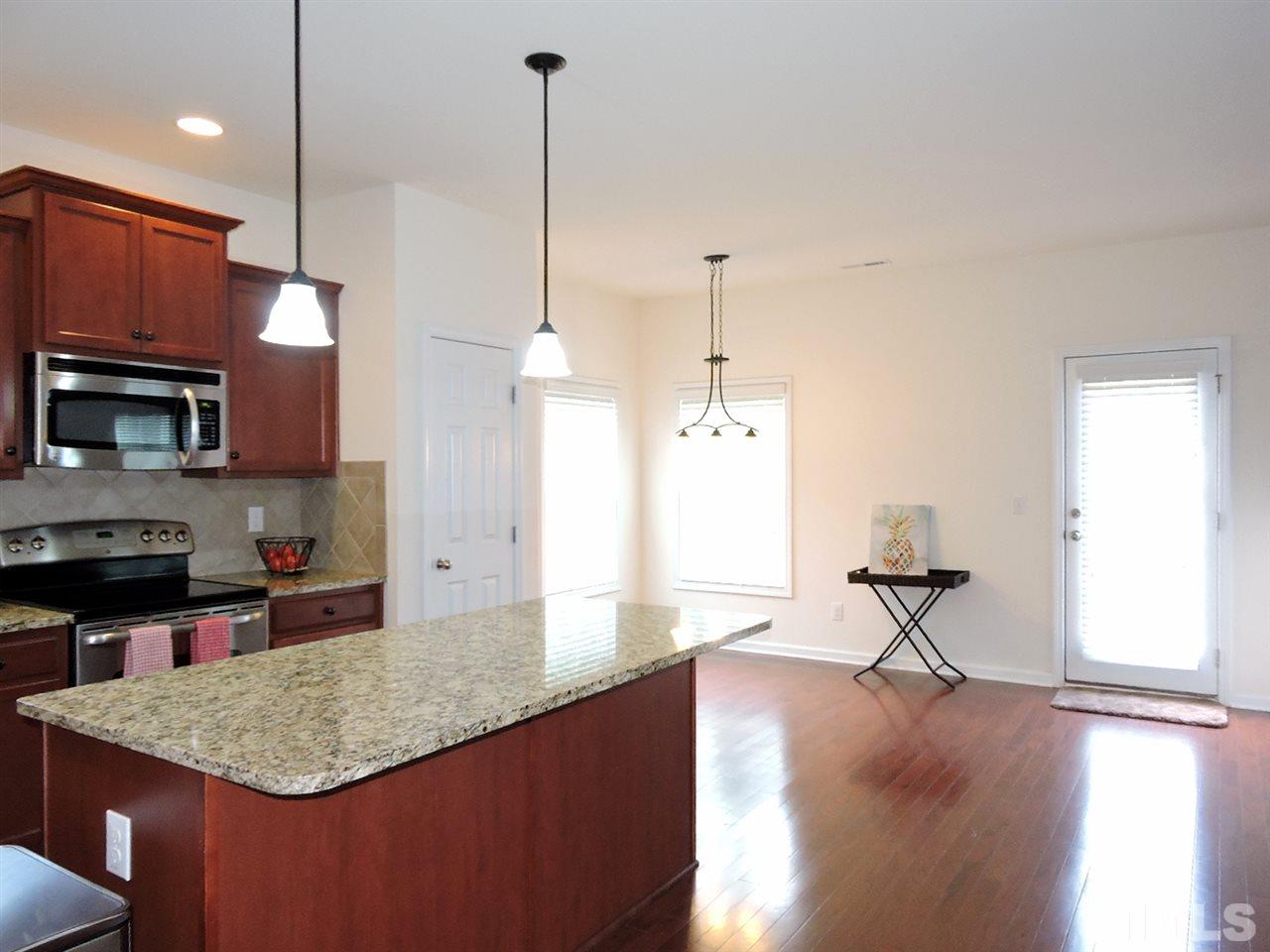 3406 Alman Drive Durham, NC 27705 - Photo 3 of 23 a kitchen with stainless steel appliances granite countertop a sink a microwave a stove and a wooden floors