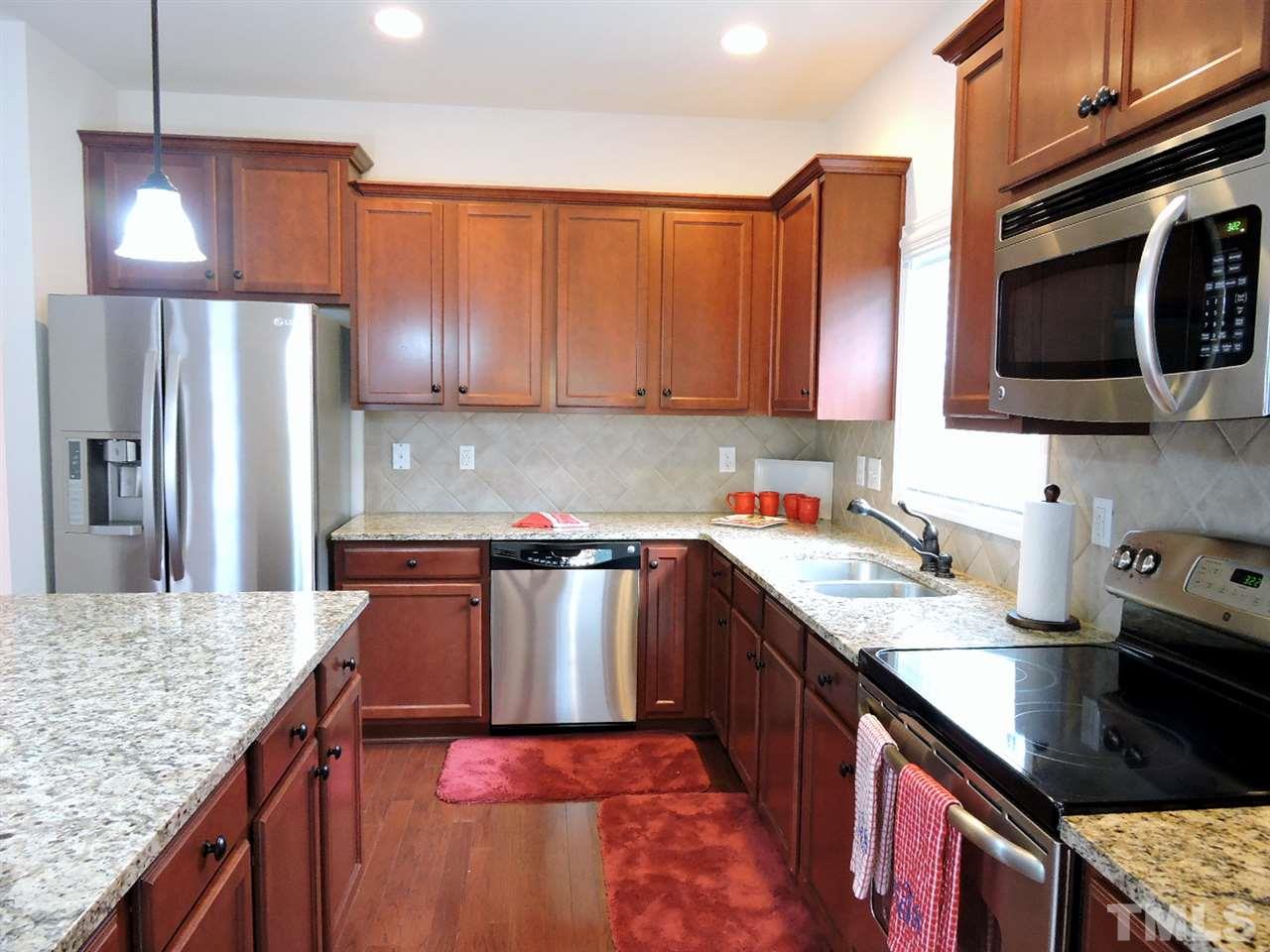3406 Alman Drive Durham, NC 27705 - Photo 5 of 23 a kitchen with stainless steel appliances granite countertop a sink a stove and a refrigerator