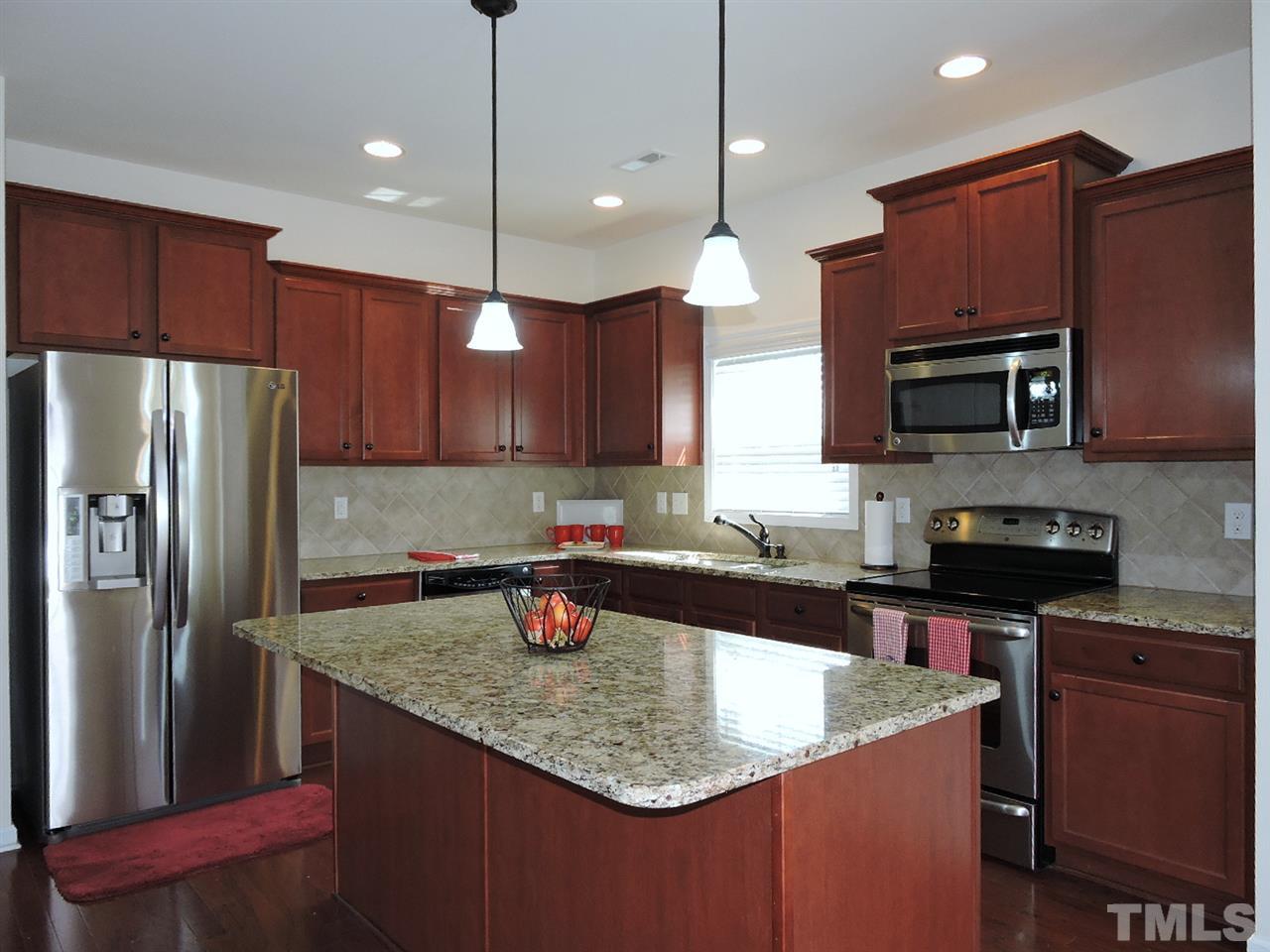 3406 Alman Drive Durham, NC 27705 - Photo 7 of 23 a kitchen with kitchen island granite countertop a sink refrigerator and microwave