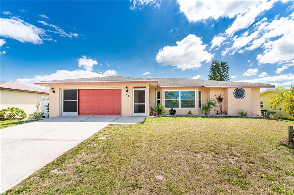 63 Caddy Road Rotonda West, FL 33947 - Photo 1 of 1 a front view of a house with a yard and garage