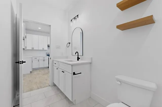 a bathroom with a double vanity sink mirror and toilet