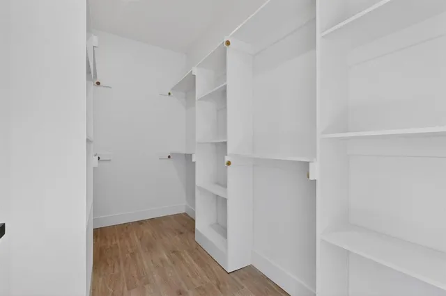 a view of walk in closet with wooden floor