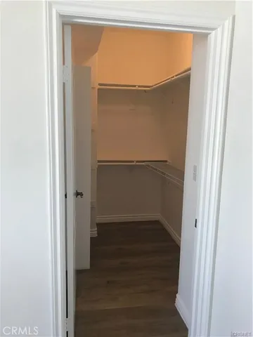 a view of walk in closet with wooden floor