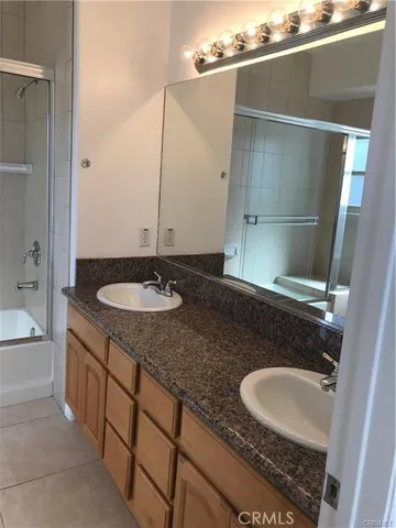 a bathroom with a granite countertop sink a mirror and a bathtub