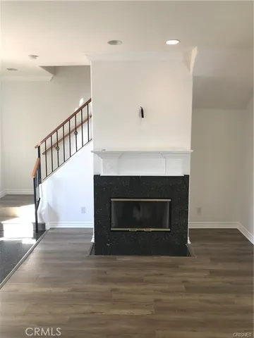 a view of an empty room wooden floor and a window