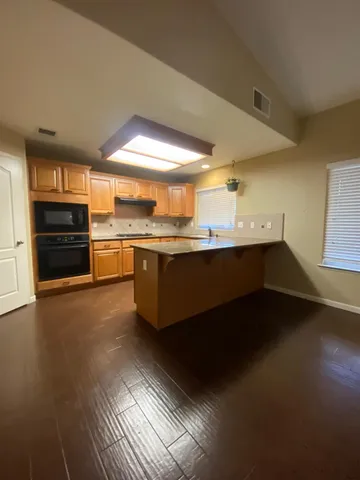 a kitchen with stainless steel appliances a sink dishwasher stove and cabinets