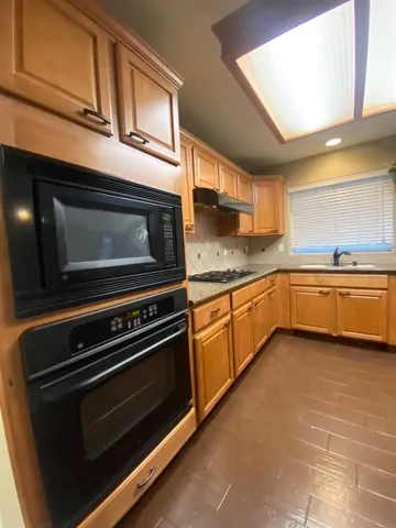 a kitchen with stainless steel appliances a stove a sink and cabinets
