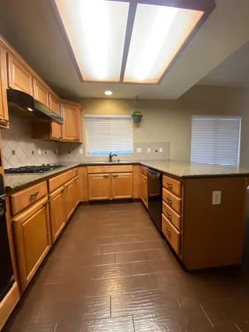 a large kitchen with stainless steel appliances granite countertop a sink and cabinets
