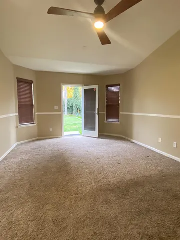 a view of empty room with a ceiling fan and window