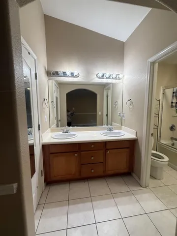 a bathroom with a granite countertop sink mirror and toilet