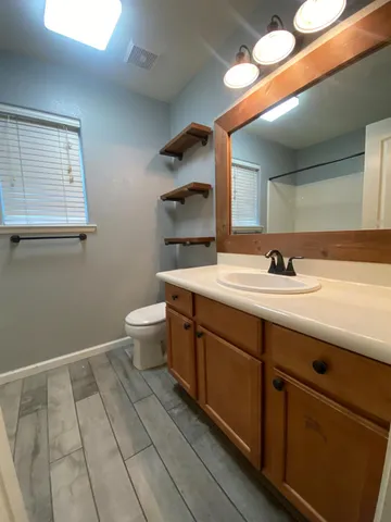 a bathroom with a toilet sink and mirror