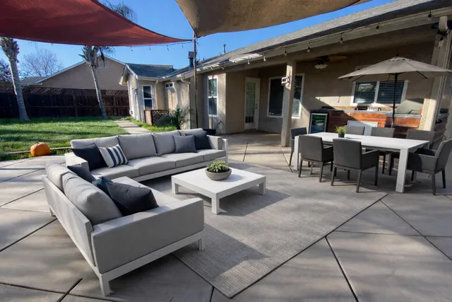 a view of a patio with couches and table under an umbrella
