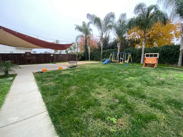 a front view of a house with a yard and tree
