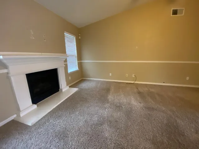 a view of empty room with a fireplace