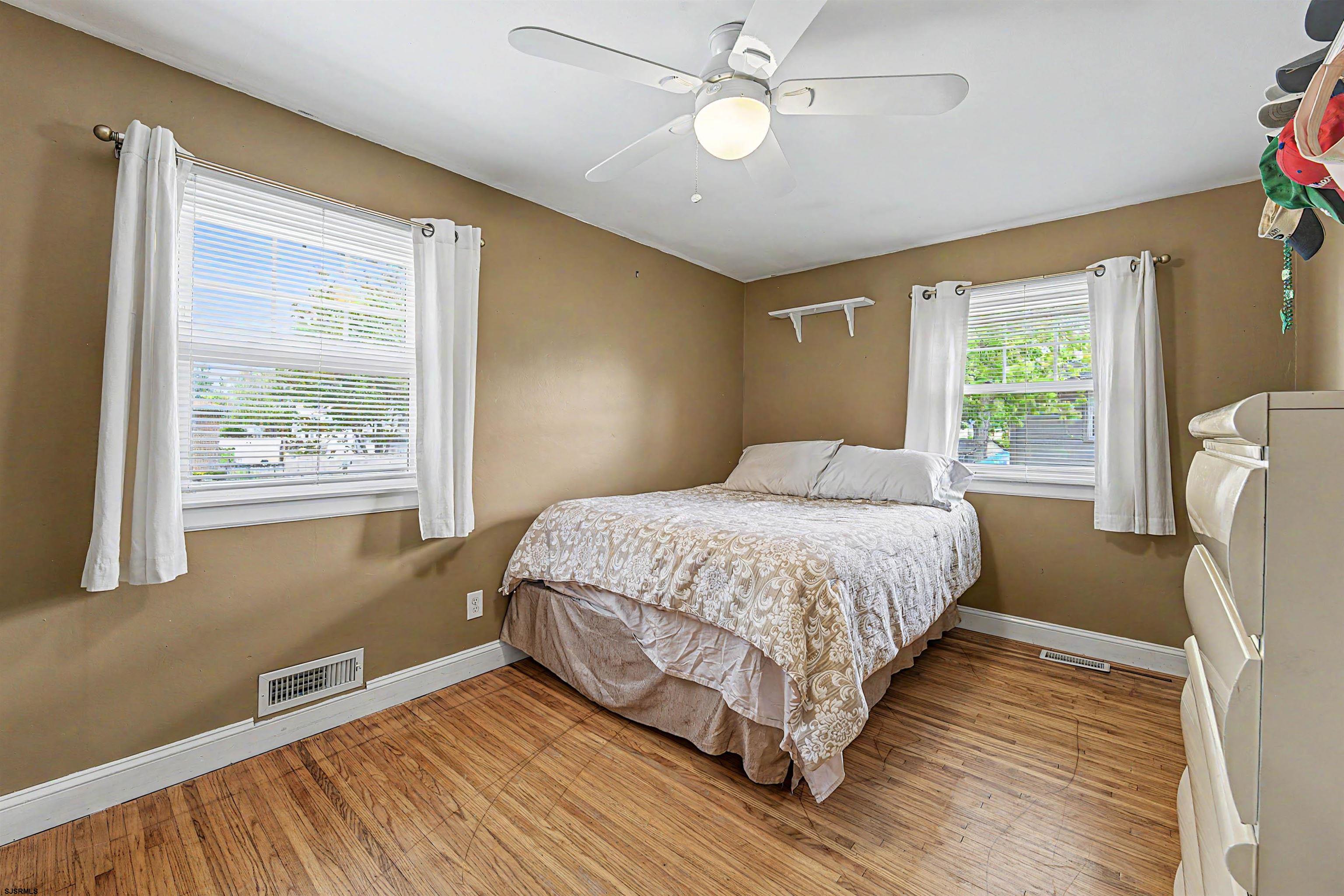 125 Exton Road Somers Point, NJ 08244 - Photo 21 of 35 a bedroom with a large bed chandelier and a window