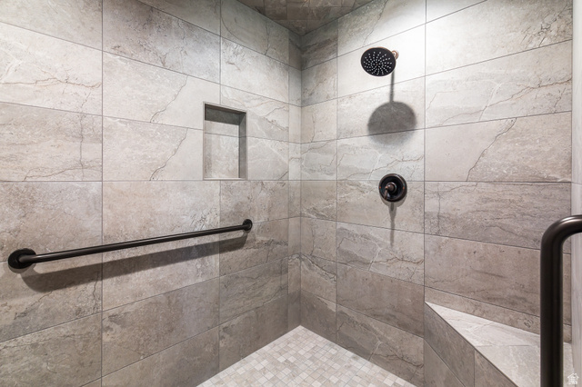 2031 South Quakie Road Koosharem, UT 84744 - Photo 21 of 33 Tiled shower with a built-in bench, recessed niche, black grab bars, and a rain shower head