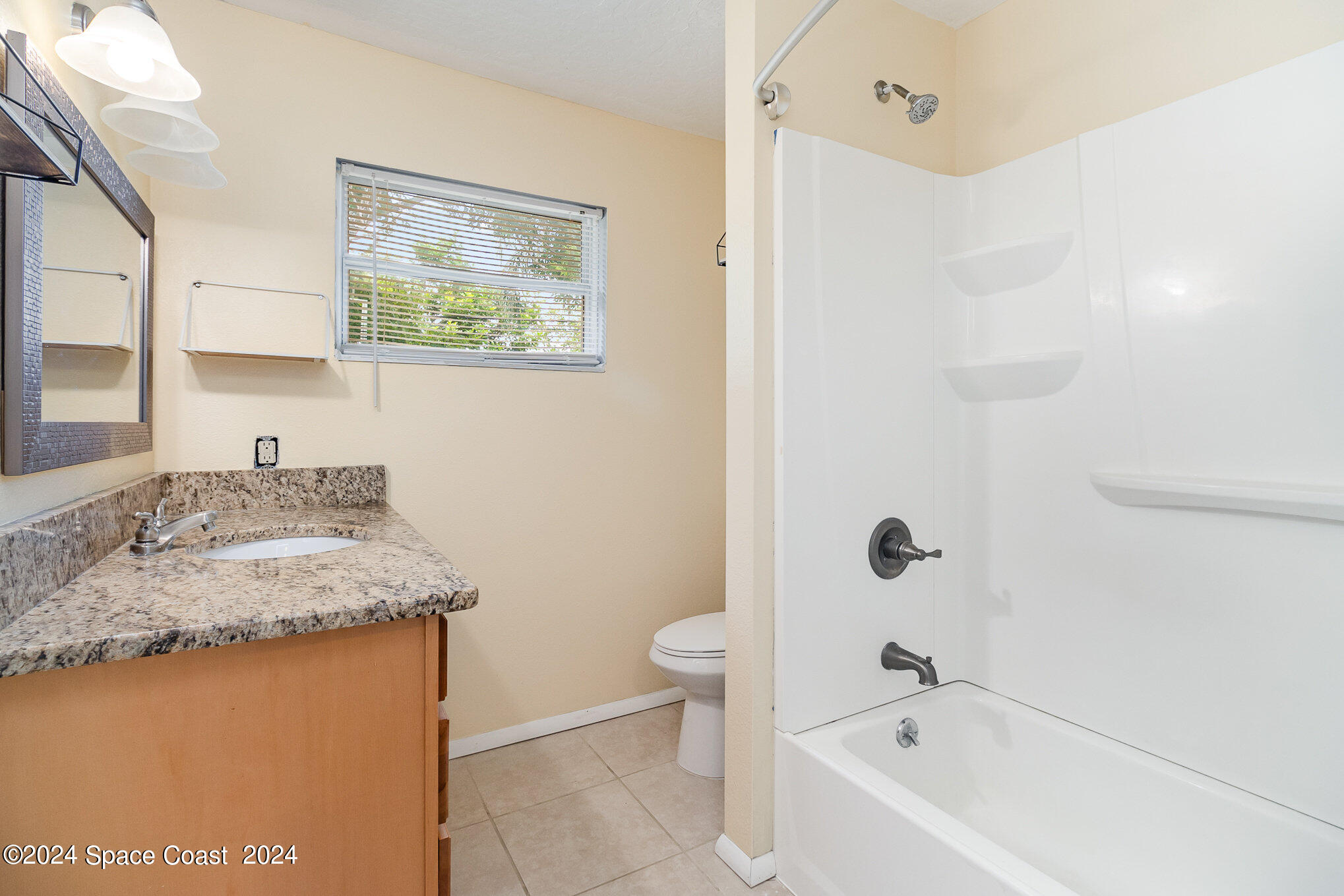 2357 Sarno Road Melbourne, FL 32935 - Photo 11 of 19 a bathroom with a granite countertop sink a toilet and shower