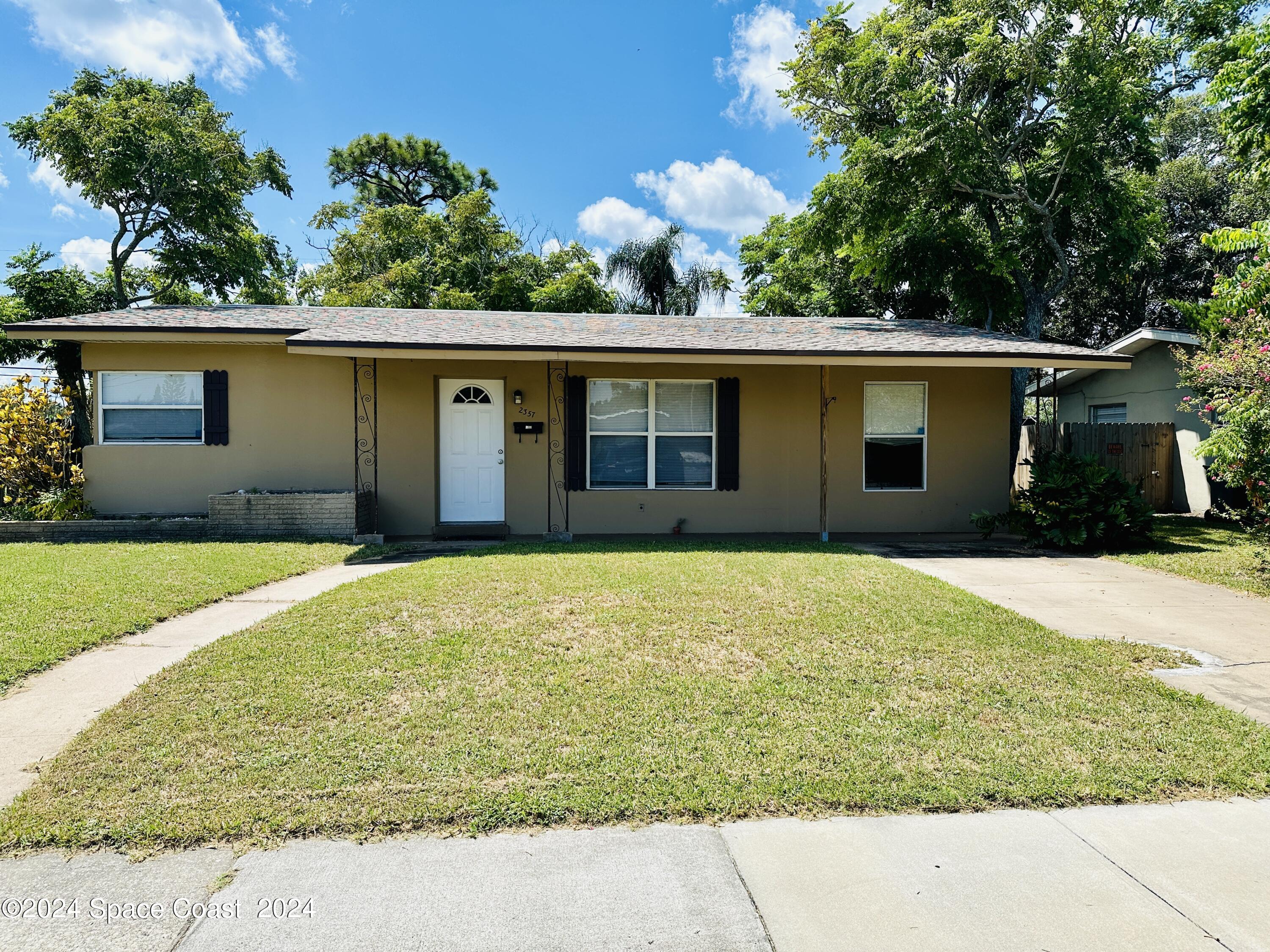 2357 Sarno Road Melbourne, FL 32935 - Photo 19 of 19 a house with trees in the background
