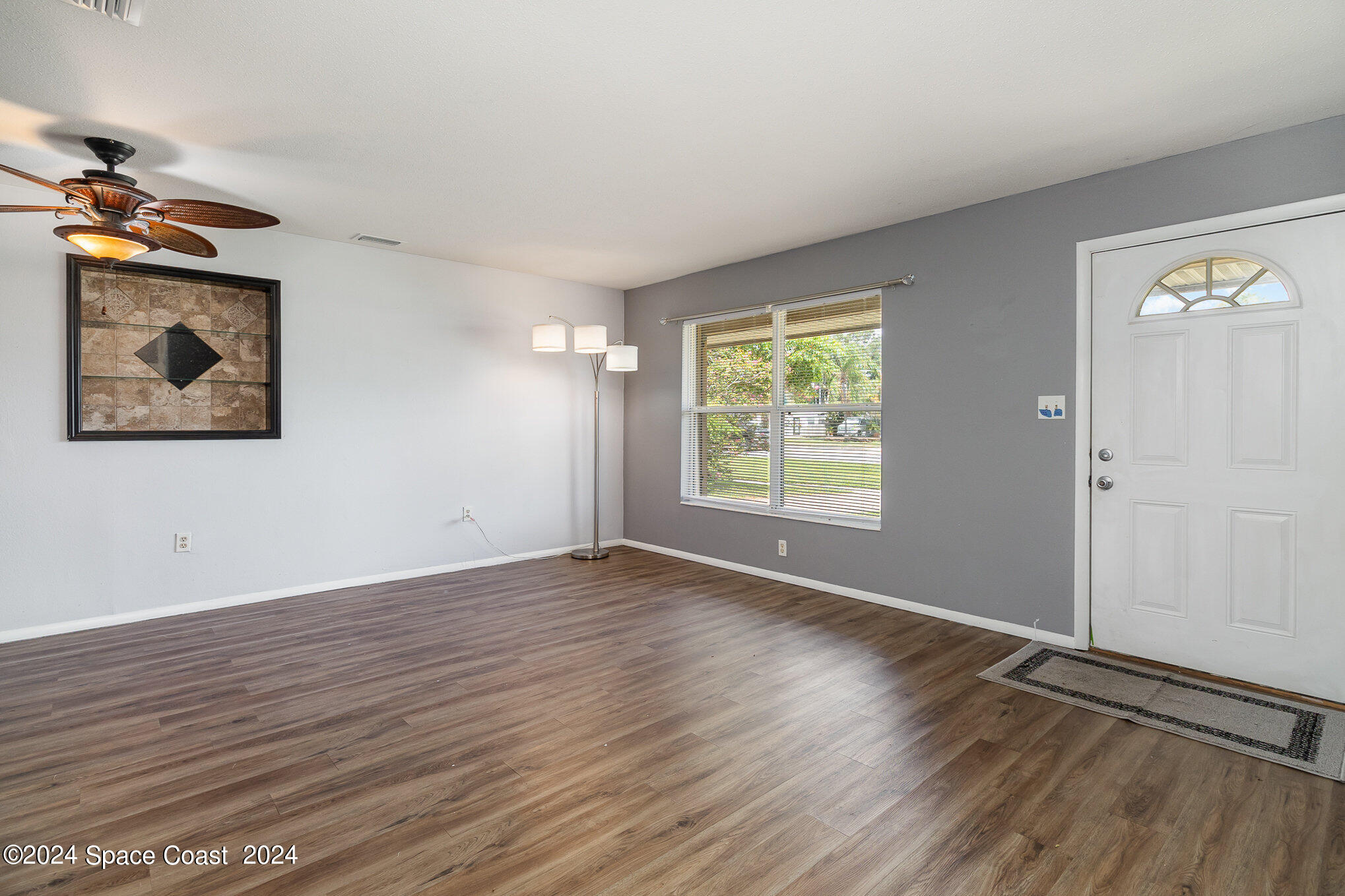 2357 Sarno Road Melbourne, FL 32935 - Photo 3 of 19 an empty room with wooden floor closet and windows