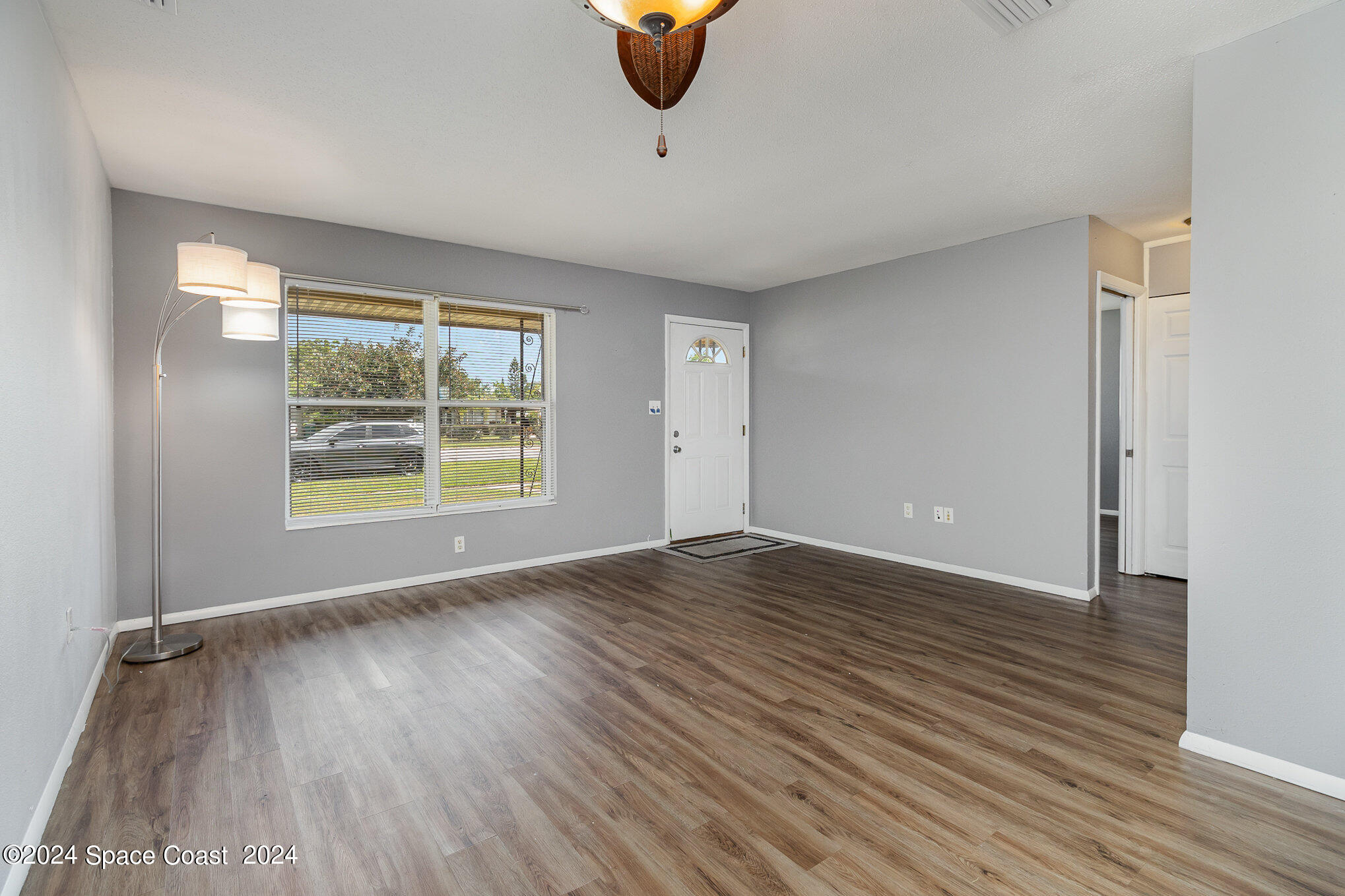 2357 Sarno Road Melbourne, FL 32935 - Photo 4 of 19 an empty room with wooden floor and windows