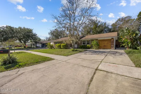 a view of a house with a yard and large tree