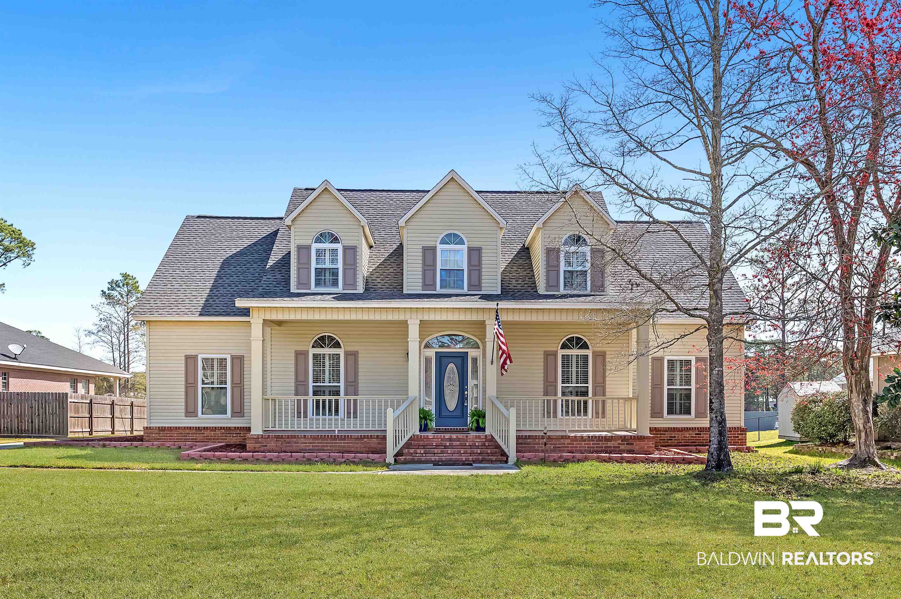 8915 Bay Point Drive Elberta, AL 36530 - Photo 2 of 74 Cape cod house featuring a shingled roof, covered porch, fence, and a front lawn