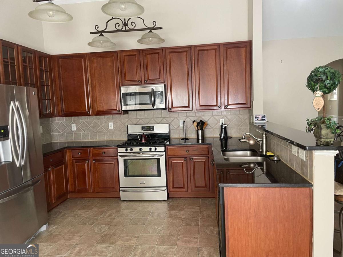 4230 Vinca Way Union City, GA 30291 - Photo 15 of 28 a kitchen with stainless steel appliances granite countertop a refrigerator stove top oven and sink