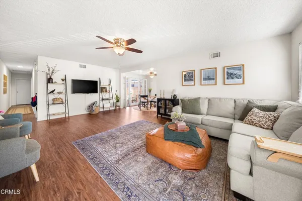 a living room with furniture and a wooden floor